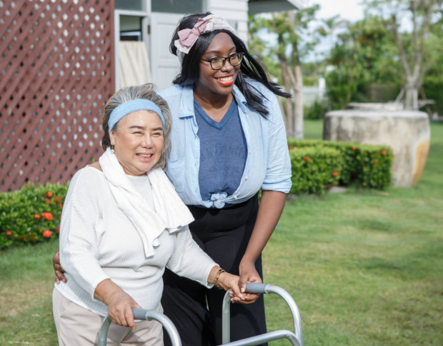 nurse walking elderly patient outdoors